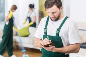 Personne en tenue de travail notant des choses sur un calepin 